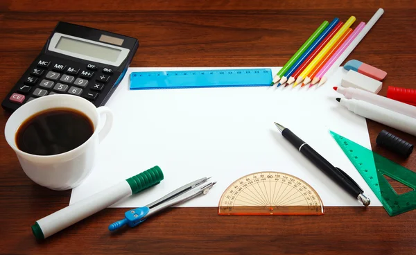 Desk with sheet of paper and stationery objects — Stock Photo, Image