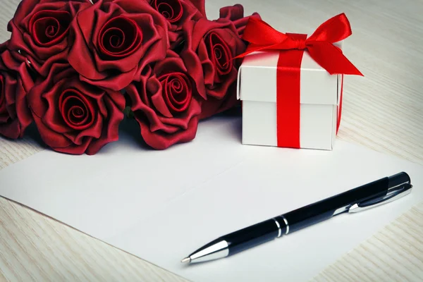 Tarjeta de felicitación en blanco con flores y regalo — Foto de Stock