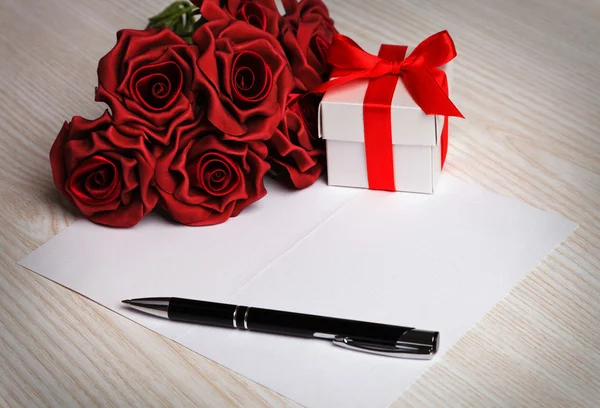 Tarjeta de felicitación en blanco con flores y regalo — Foto de Stock