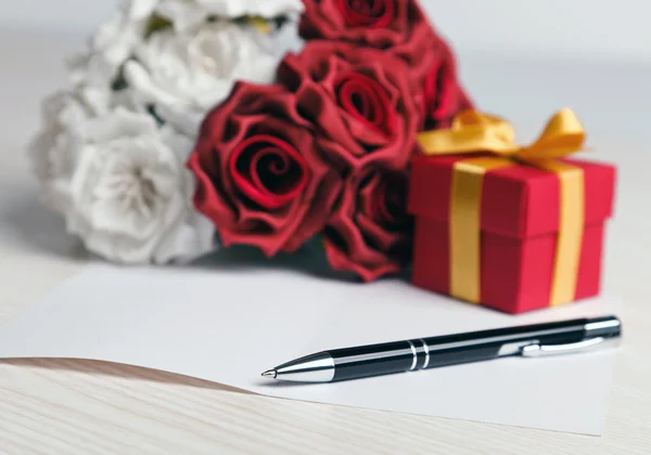Saludo tarjeta en blanco con flores y regalo — Foto de Stock