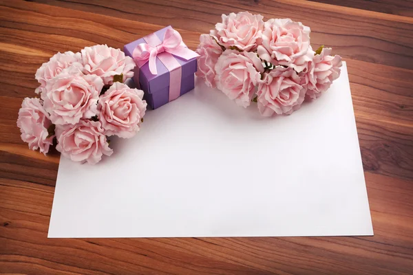 Tarjeta de felicitación en blanco con rosas y regalo — Foto de Stock