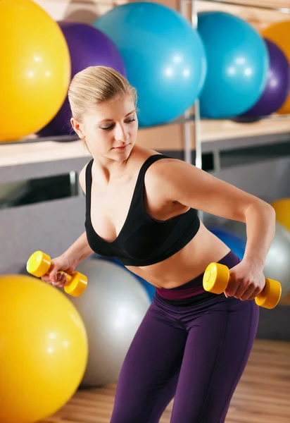 Beautiful blonde in sport gym with dumbbells — Stock Photo, Image