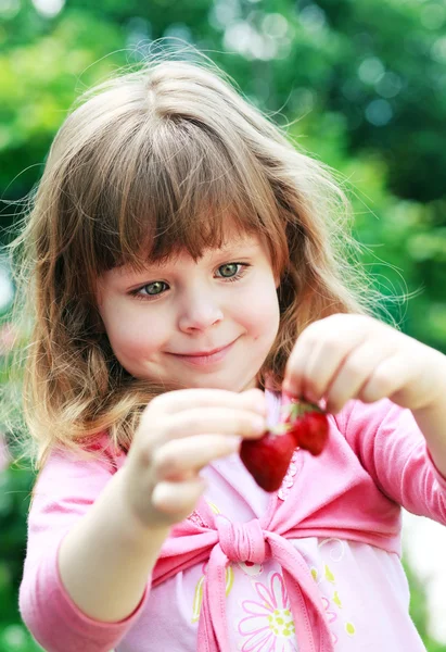 Girl holds strawberries — Stock Photo, Image