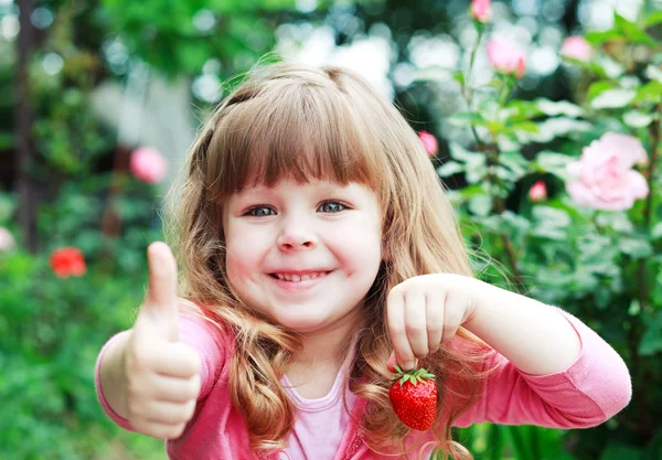 Liten flicka med jordgubb, säger ok — Stockfoto