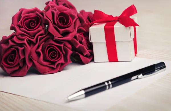 Tarjeta de felicitación en blanco con flores y regalo — Foto de Stock