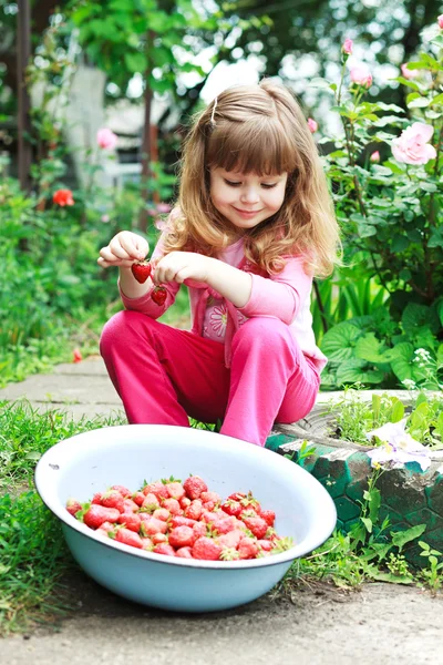 Chica sonriente sosteniendo el tazón de fresas — Foto de Stock