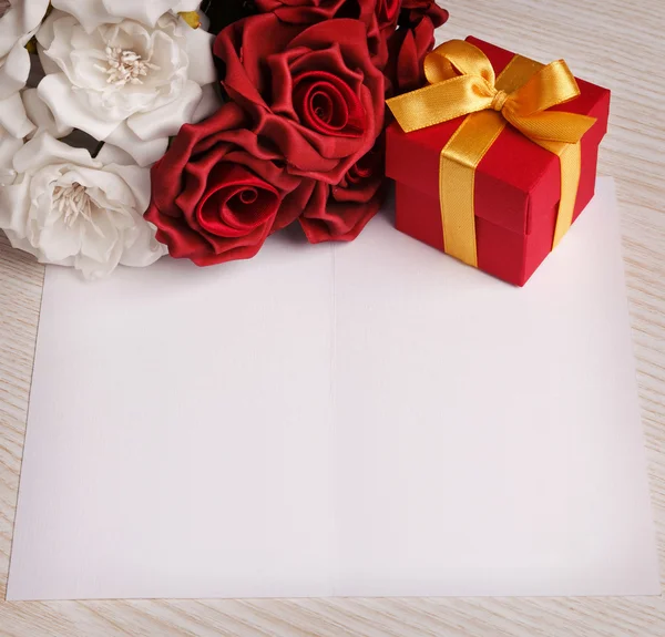 Lege wenskaart met bloemen en cadeau — Stockfoto