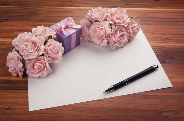 Biglietto di auguri bianco con rose e regalo — Foto Stock