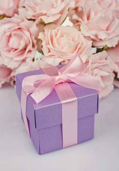 Roze bloemen en doos van de gift — Stockfoto