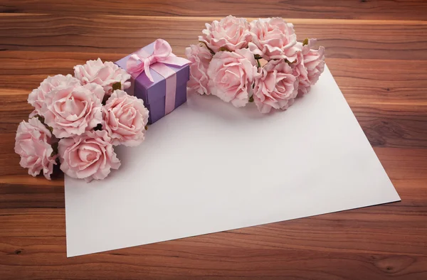 Tarjeta de felicitación en blanco con rosas y regalo —  Fotos de Stock