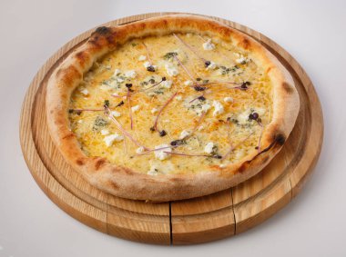 Tahta tezgahta sıcak pizzanın en üst görüntüsü. Pizza Formaggio, 5 peynir mozzarella, dutch, feta, dorblu, parmesan peyniri..