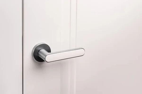 Door handles elements close up. Door handle on white closed doors in modern loft style in interior. Concept of accessories for interior design home interior of apartment or office.