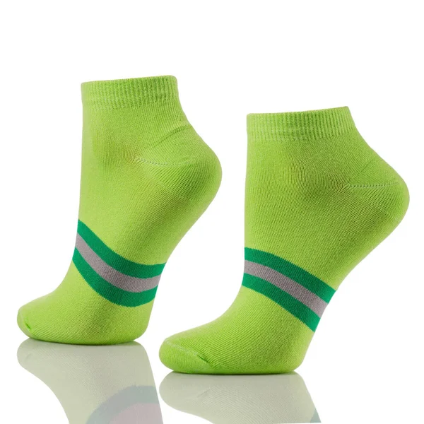 把一双运动型棉袜放在看不见的腿上 与白色背景隔离 一套用于广告 标识或品牌布局的绿色短袜 图库图片
