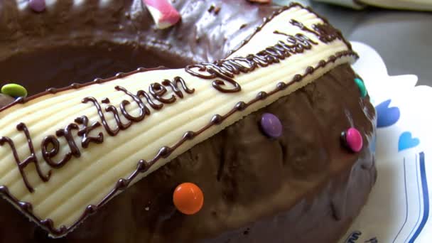 Muñeca de panadería alemana alrededor de pastel de cumpleaños cerca — Vídeo de stock