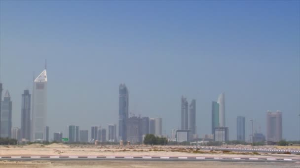 Liten bil cross Dubais skyline pan burj emirates 10299 — Stockvideo