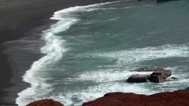 Einsamer Mann zu Fuß Wasser schwarz vulkanischen Strand 10507 — Stockvideo