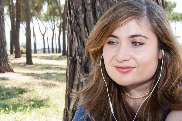 Pretty Girl escucha música en el prado — Foto de Stock