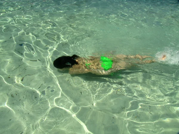 Mladá dívka hraje hry v mělké zelené vodě vahti beach, thassos, Řecko — Stock fotografie