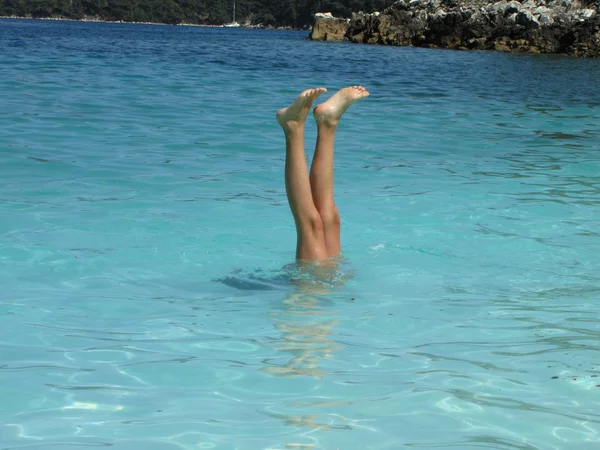 Dítě hraje voda hry v tyrkysově modrou vodou mramorové Beach, ostrov thassos, Řecko — Stock fotografie