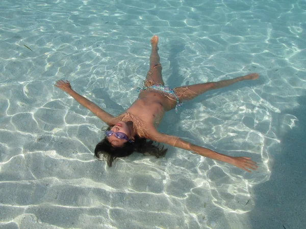 Bambino gode la vita che si trova sulla superficie turchese dell'acqua blu della spiaggia di marmo, isola di Taso, Grecia — Foto Stock