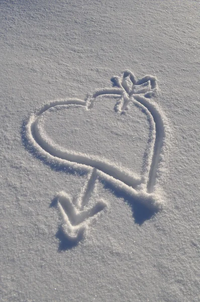 Hart and arrow shape drawn on white snow surface — Stock Photo, Image