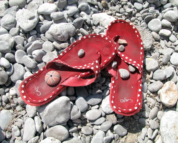 Rote Sandalen auf Kieselstein — Stockfoto