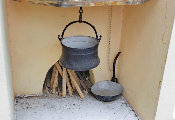 Ancient fireplace with vessel for cook — Stock Photo, Image