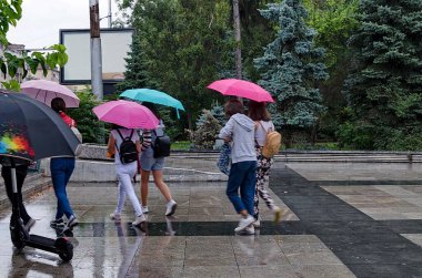 Sofya, Bulgaristan - 19 Eylül 2021: Bir grup genç Bulgaristan 'ın başkenti Sofya' da yağmurda yürüyor. Ziyaret yerinde..