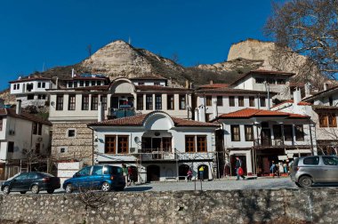 Melnik, Bulgaristan - 03 Mart 2012: Bulgaristan 'ın Melnik kentindeki ünlü kum piramitlerinin arka planına karşı eski geleneksel evler. Ziyaret yerinde..