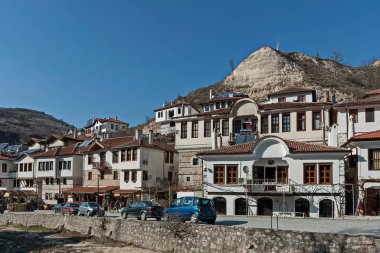 Melnik, Bulgaristan - 03 Mart 2012: Bulgaristan 'ın Melnik kentindeki ünlü kum piramitlerinin arka planına karşı eski geleneksel evler. Ziyaret yerinde..