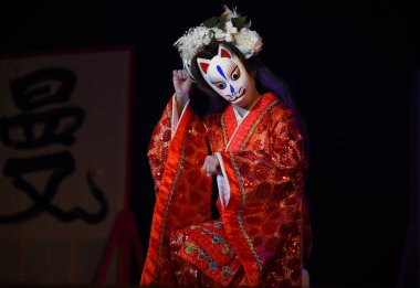 Japon tiyatro oyuncuları maske takarak oryantal dans ediyorlar..