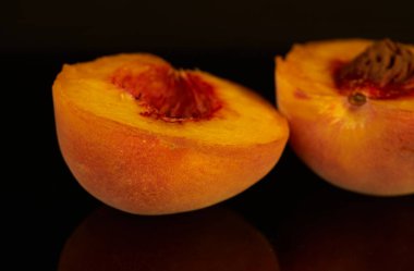 yellow peaches lie on a black background, fruit