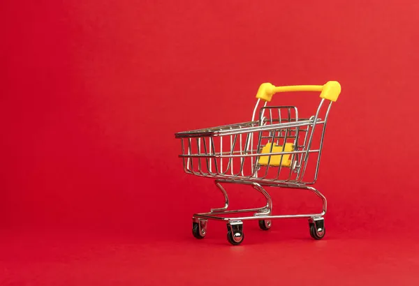 赤い背景に空のショッピングトロリーカートのクローズアップ スパックのコピー ストック画像