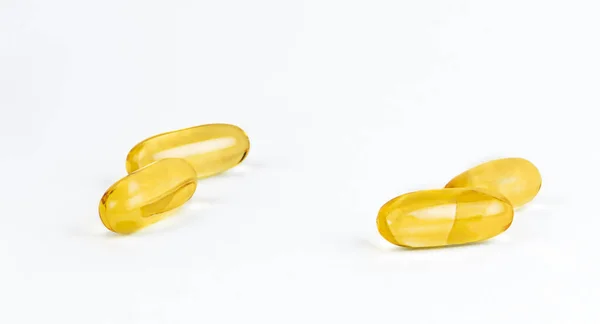 柔らかいゲルカプセルの中の黄金の油サプリメントの近くのUo 健康的な製品の概念 — ストック写真