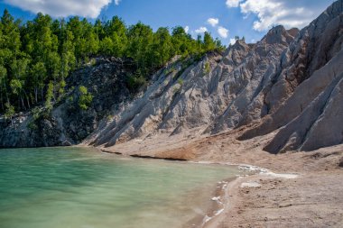 Dağlarda yeşil ormanlı güzel mavi bir göl.
