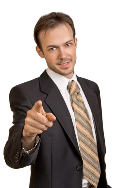 Smiling young businessman points to camera — Stock Photo, Image