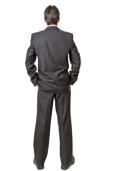 Parte posterior del hombre en traje negro manteniendo las manos en los bolsillos — Foto de Stock