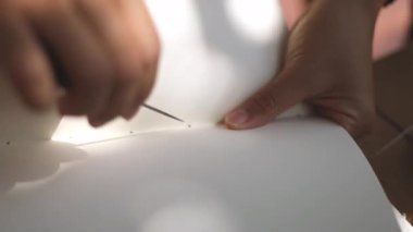 Kadının elleri stüdyoda kitap yapıyor.