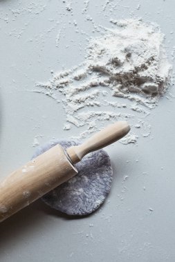 Çiğ pizza hamuru ve beyaz arka planda merdane. 