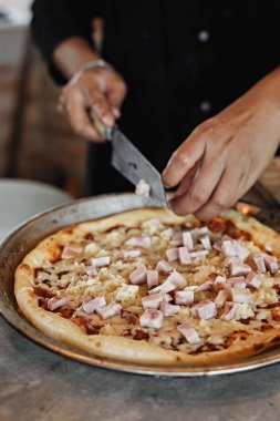 Şef fırıncı mutfakta pizza yapıyor. Seçici odaklanma.