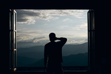 Güzel bir dağ ve doğa manzarasına bakan bir yolcunun dikiz görüntüsü.