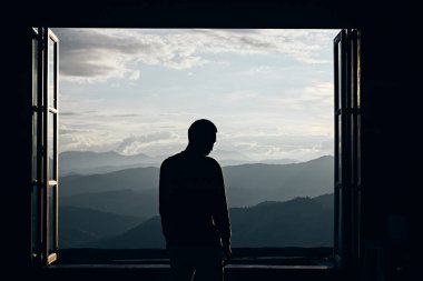 Güzel bir dağ ve doğa manzarasına bakan bir yolcunun dikiz görüntüsü.