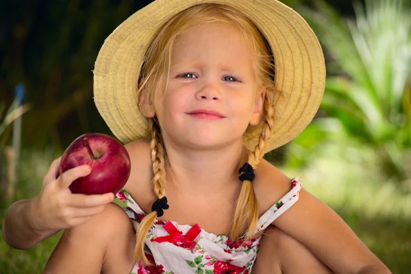 Het meisje in een hoed met rode appel — Stockfoto