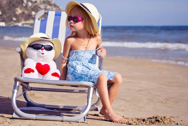 şezlong ile bir oyuncak bir çocuk oturur