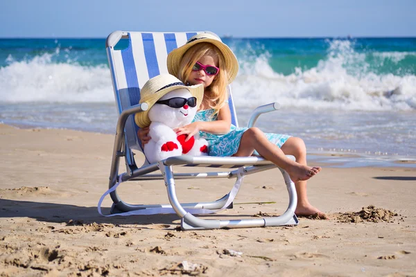 şezlong ile bir oyuncak bir çocuk oturur