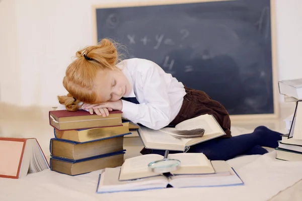 Menina dormindo em livros — Fotografia de Stock