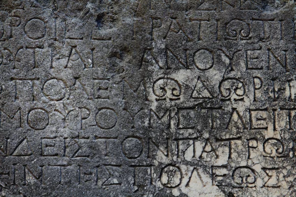 A Greek inscription carved in stone at ancient ruins — Stock Photo, Image