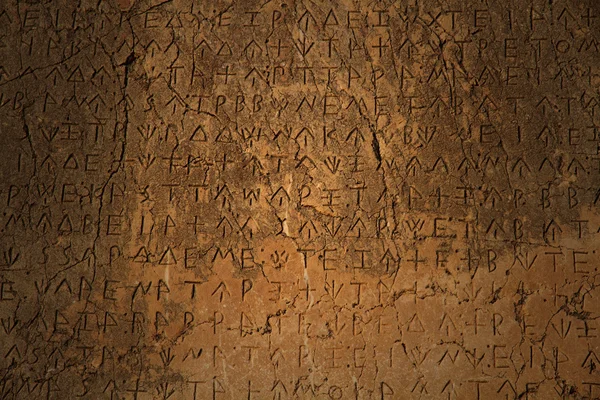 A Greek inscription carved in stone at ancient ruins — Stock Photo, Image