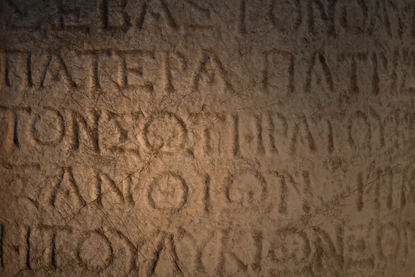 En inskription hugget i sten på gamle ruiner - Stock-foto