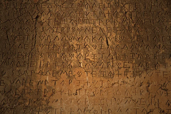 En grekisk inskrift ristade i sten på fornlämningar Stockbild